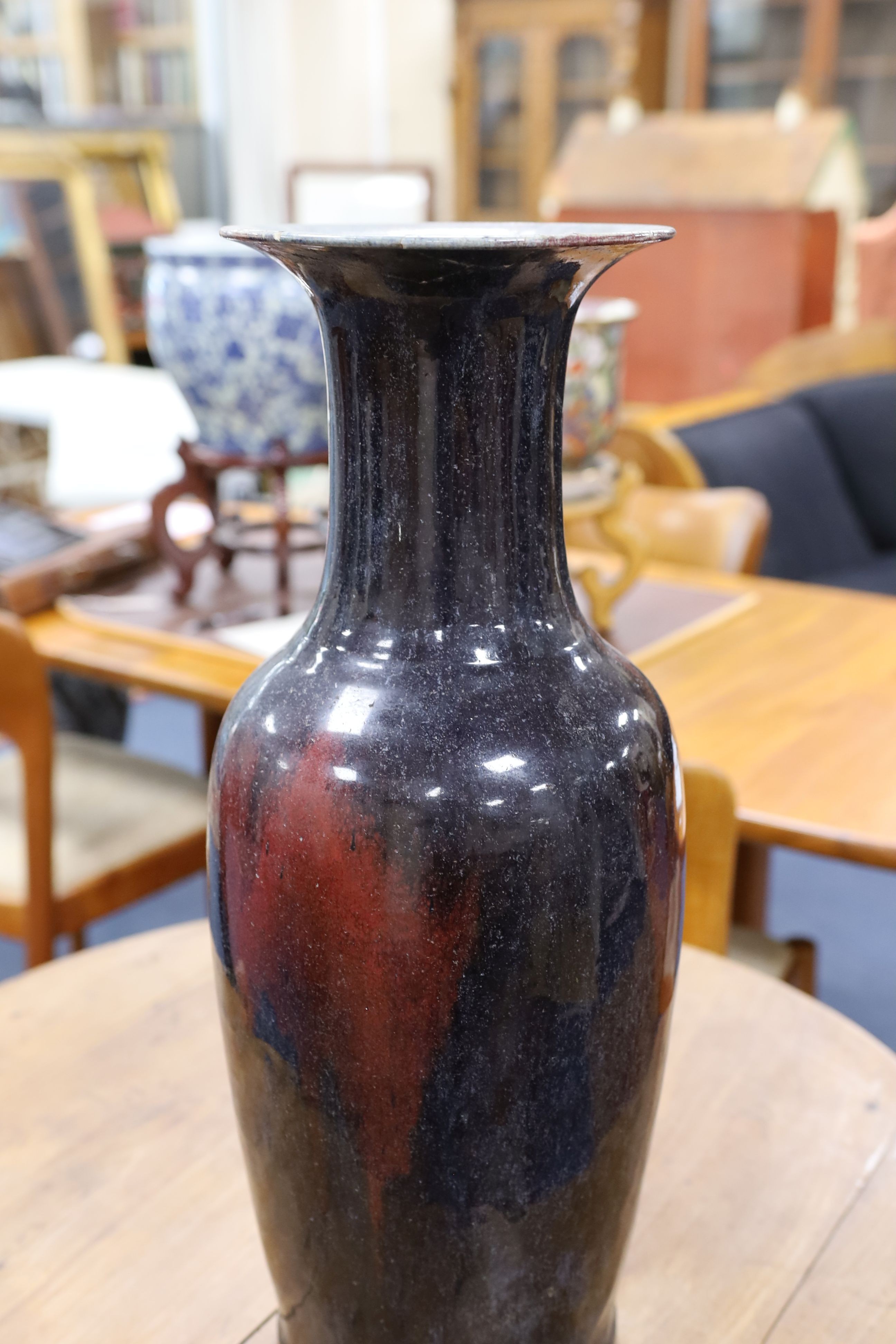 A large Chinese sang de boeuf glazed vase on carved wooden stand., Vase 61 cms high not including stand.